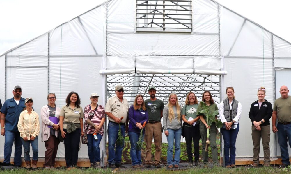 People standing in front of a high tunnel